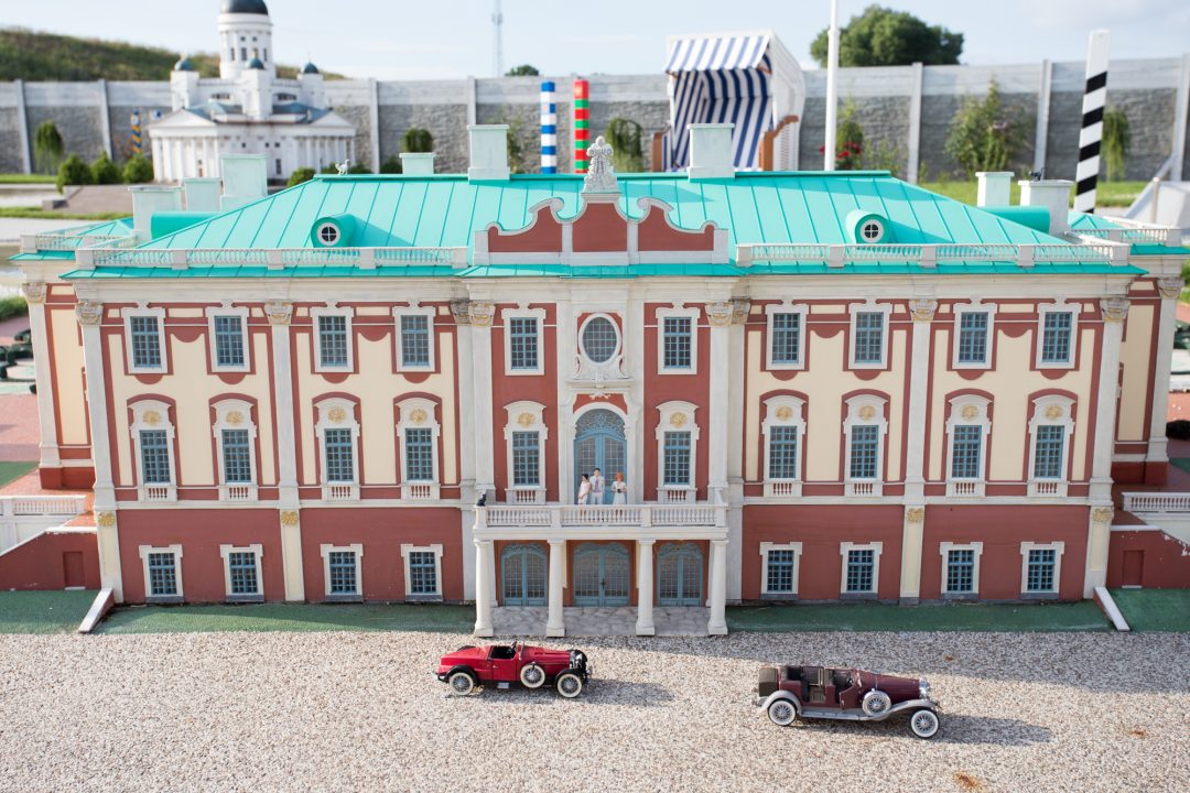 Miniatura pałacowej fasady z zielonym dachem i symetrycznymi rzędami okien.